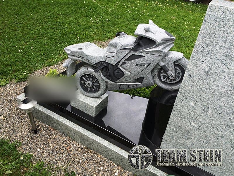 Motorrad-Skulptur aus Granit auf einem Grabmal mit schwarz polierter Platte